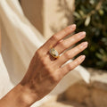 Close-up of a feminine hand gently moving through warm summer sunlight, wearing a 4.55g Fine Gold 18k yellow gold ring. صورة مقربة ليد أنثوية تتحرك بنعومة تحت ضوء شمس الصيف، وترتدي خاتم فاين جولد ذهب أصفر عيار 18 بوزن 4.55 جرام.