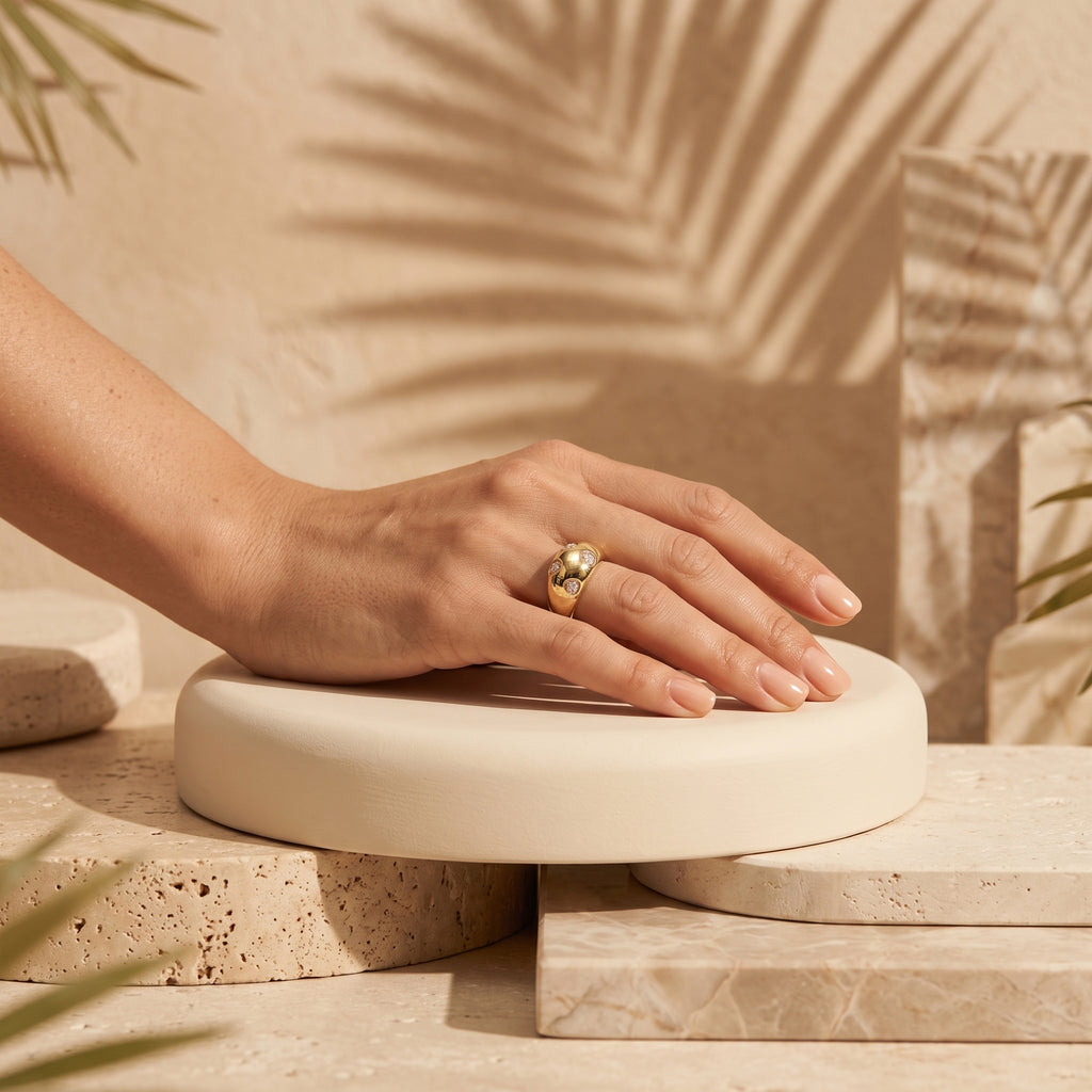 4g L'azurde gold dome ring on a woman's hand resting on a sculptural pedestal with tropical shadows. خاتم لازوردي ذهب بومبيه بوزن 4 جرام على يد امرأة تستريح على منصة منحوتة مع ظلال استوائية.