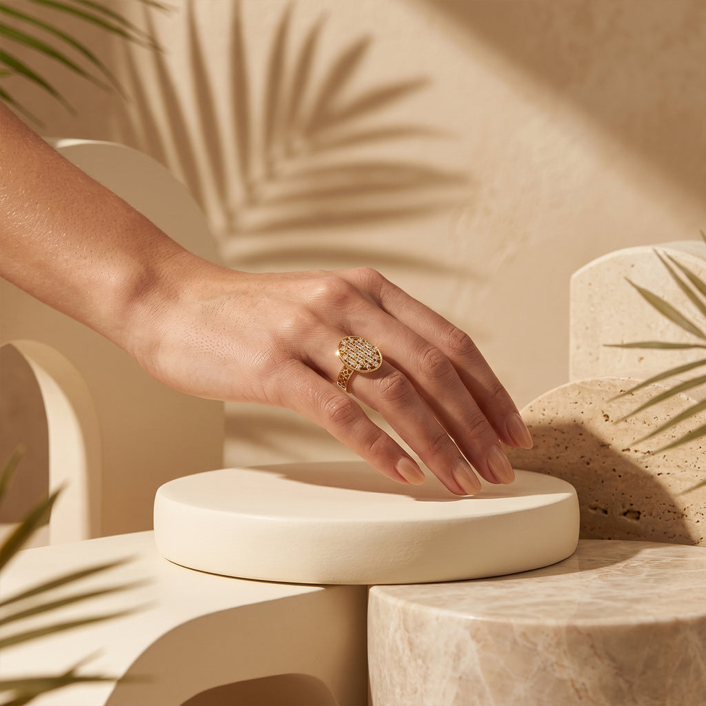 Elegant woman's hand wearing the Loaloaa gold ring resting on a sculptural ivory pedestal.	يد امرأة أنيقة ترتدي خاتم لؤلؤة الذهبي وتستند على قاعدة نحتية فاخرة.