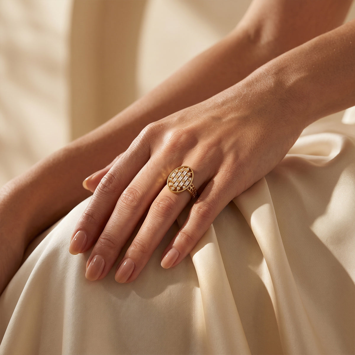Loaloaa gold statement ring on a woman's hand resting gracefully on luxurious ivory silk.	خاتم لؤلؤة الذهبي على يد امرأة تستريح بنعومة على قماش حرير عاجي فاخر.