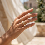 Close-up of a woman's hand wearing the Loaloaa gold ring in warm summer sunlight.	لقطة مقربة ليد امرأة ترتدي خاتم لؤلؤة الذهبي تحت أشعة شمس الصيف الدافئة.