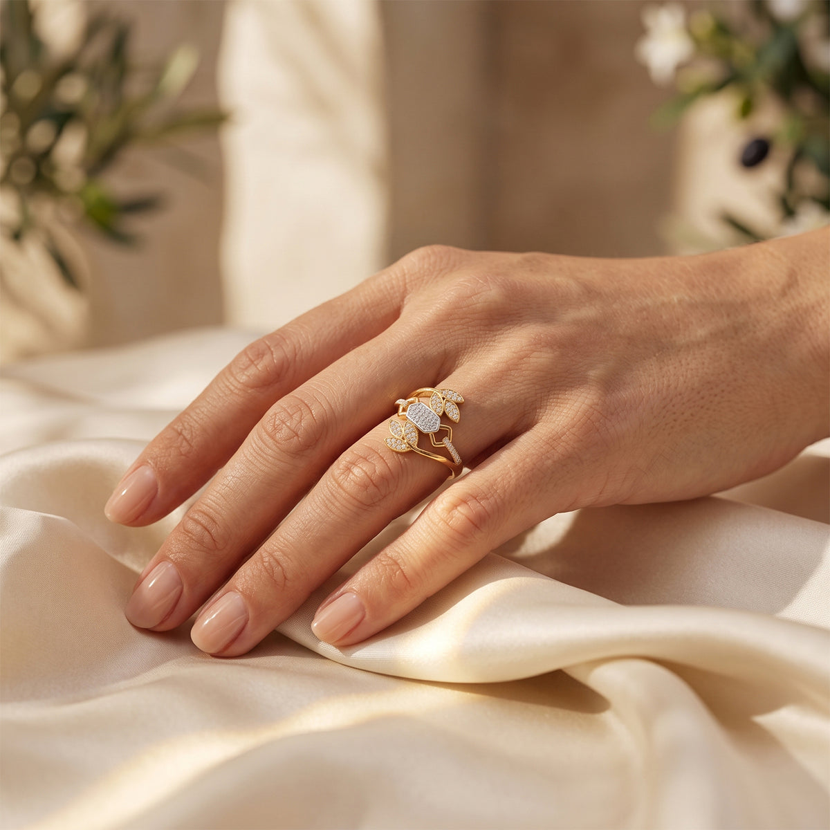 Fine Gold leaf ring on a woman's hand resting gracefully on luxurious ivory silk.	خاتم فاين جولد الذهبي على يد امرأة تستريح بنعومة على قماش حرير عاجي فاخر.