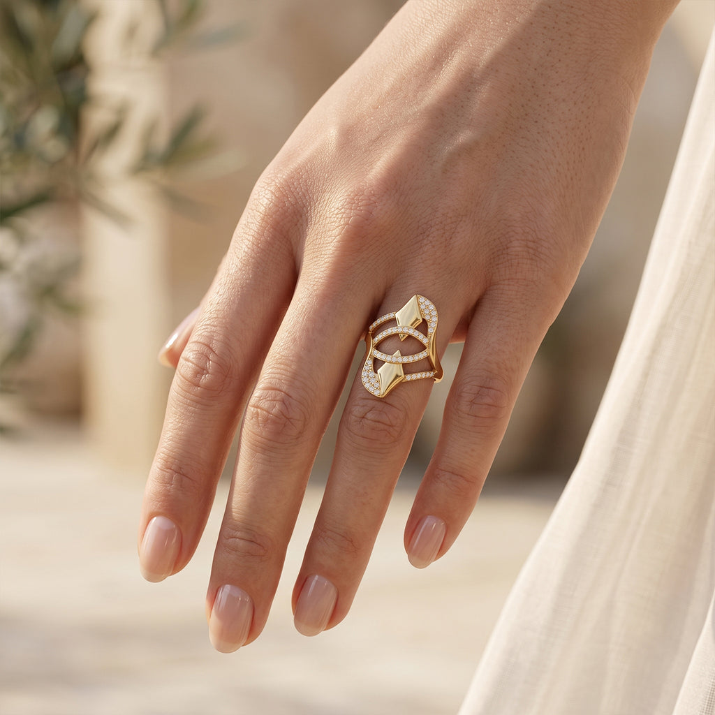 Close-up of a woman's hand wearing the Fine Gold abstract pave ring in warm sunlight.	لقطة مقربة ليد امرأة ترتدي خاتم فاين جولد الهندسي تحت أشعة الشمس الدافئة.