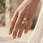 Close-up of a woman's hand wearing the Fine Gold abstract pave ring in warm sunlight.	لقطة مقربة ليد امرأة ترتدي خاتم فاين جولد الهندسي تحت أشعة الشمس الدافئة.