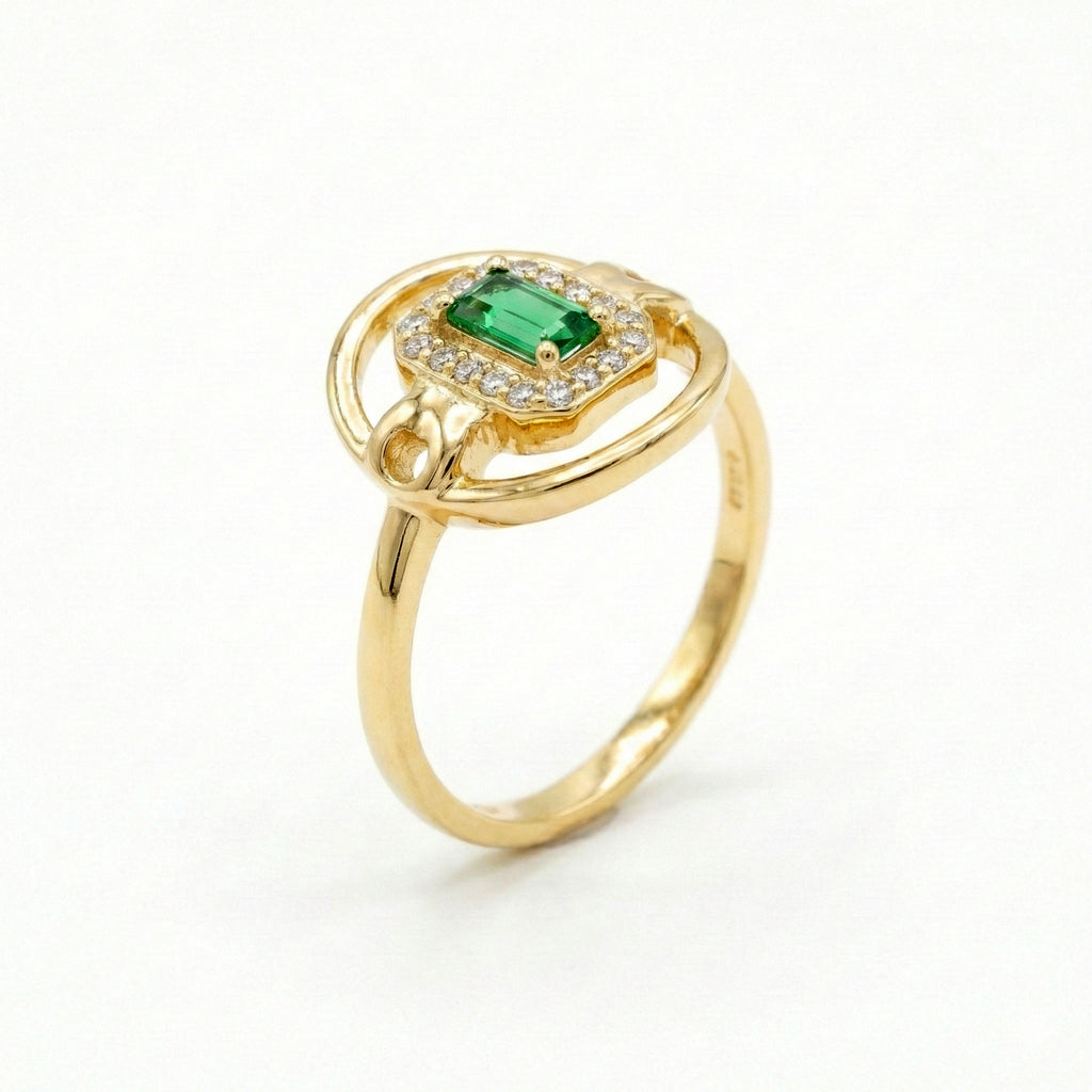 Gold ring with a green gemstone on a white background