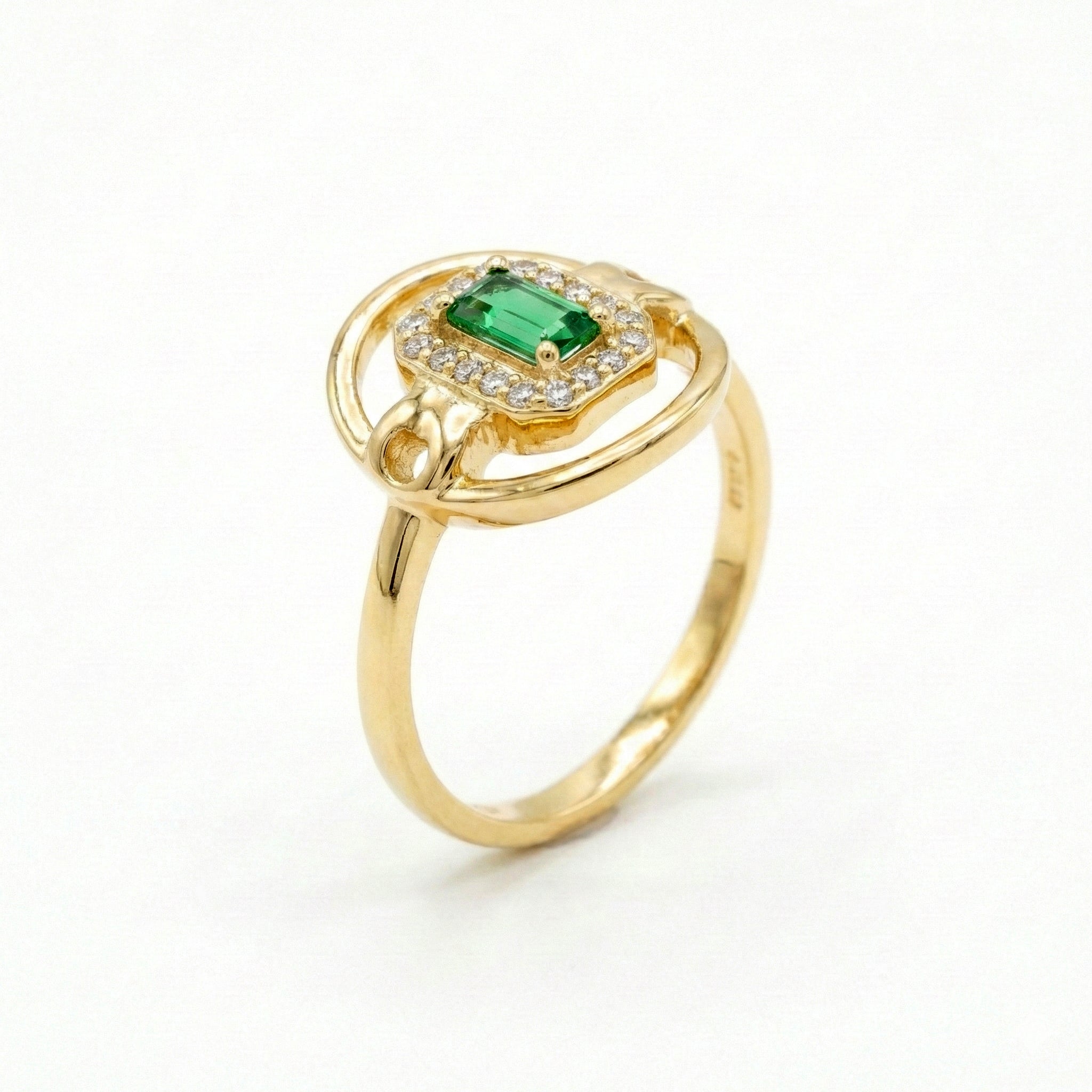 Gold ring with a green gemstone on a white background