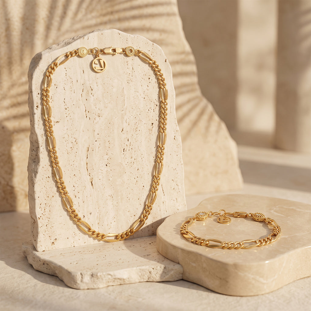 L'azurde 18K gold Gourmet necklace and bracelet set elegantly displayed on textured stone pedestals.	طقم ذهب لازوردي عيار 18 بتصميم جرميت معروض بأناقة على منصات حجرية مزخرفة.