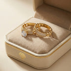 Gold ring with a diamond on a beige velvet cushion in a jewelry box