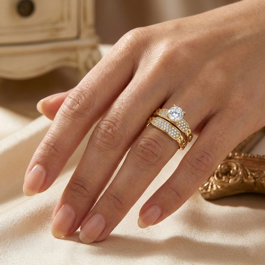 Hand wearing a gold ring with a diamond on a beige surface