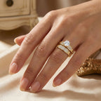 Hand wearing a gold ring with a diamond on a beige surface