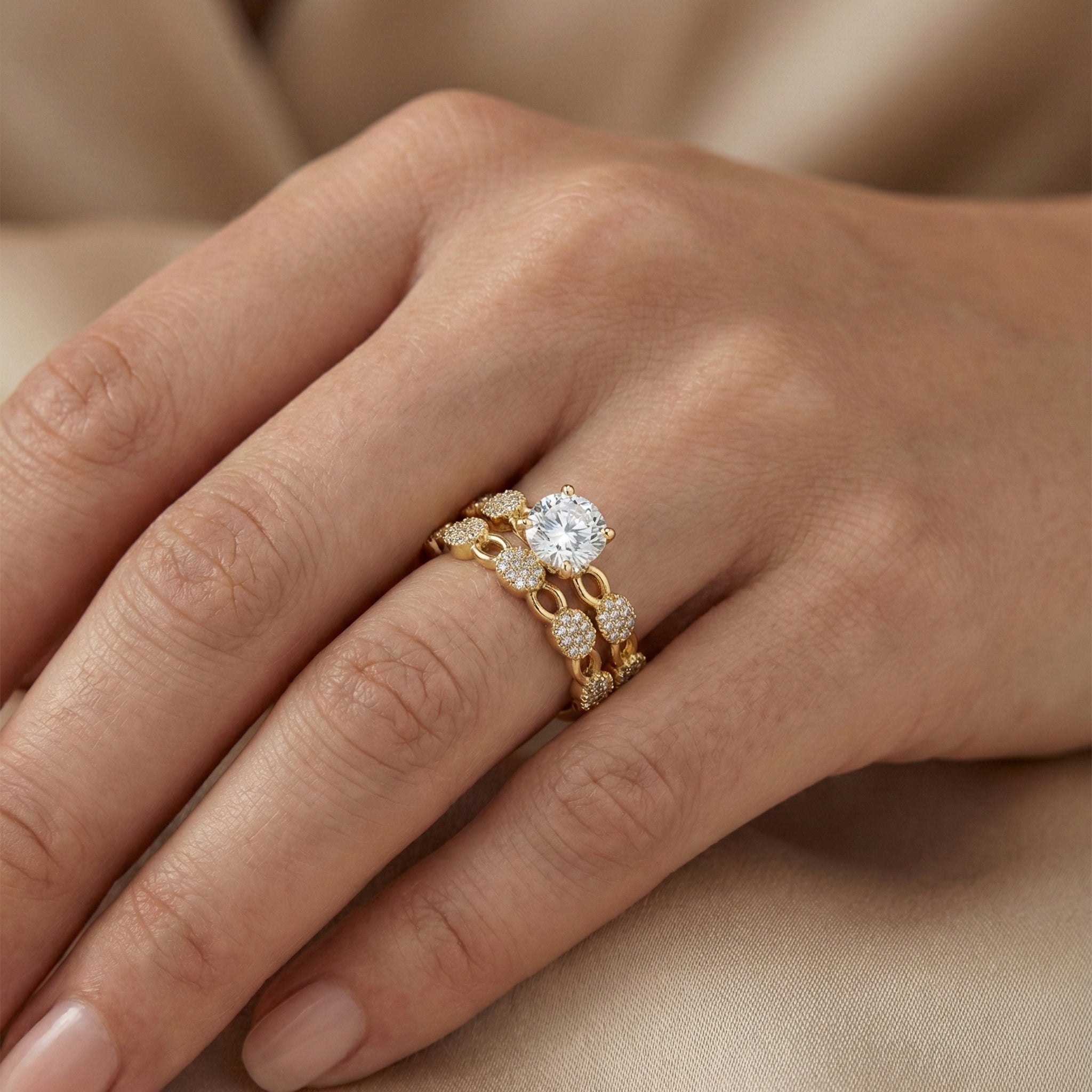 Gold ring with a diamond on a hand against a beige background