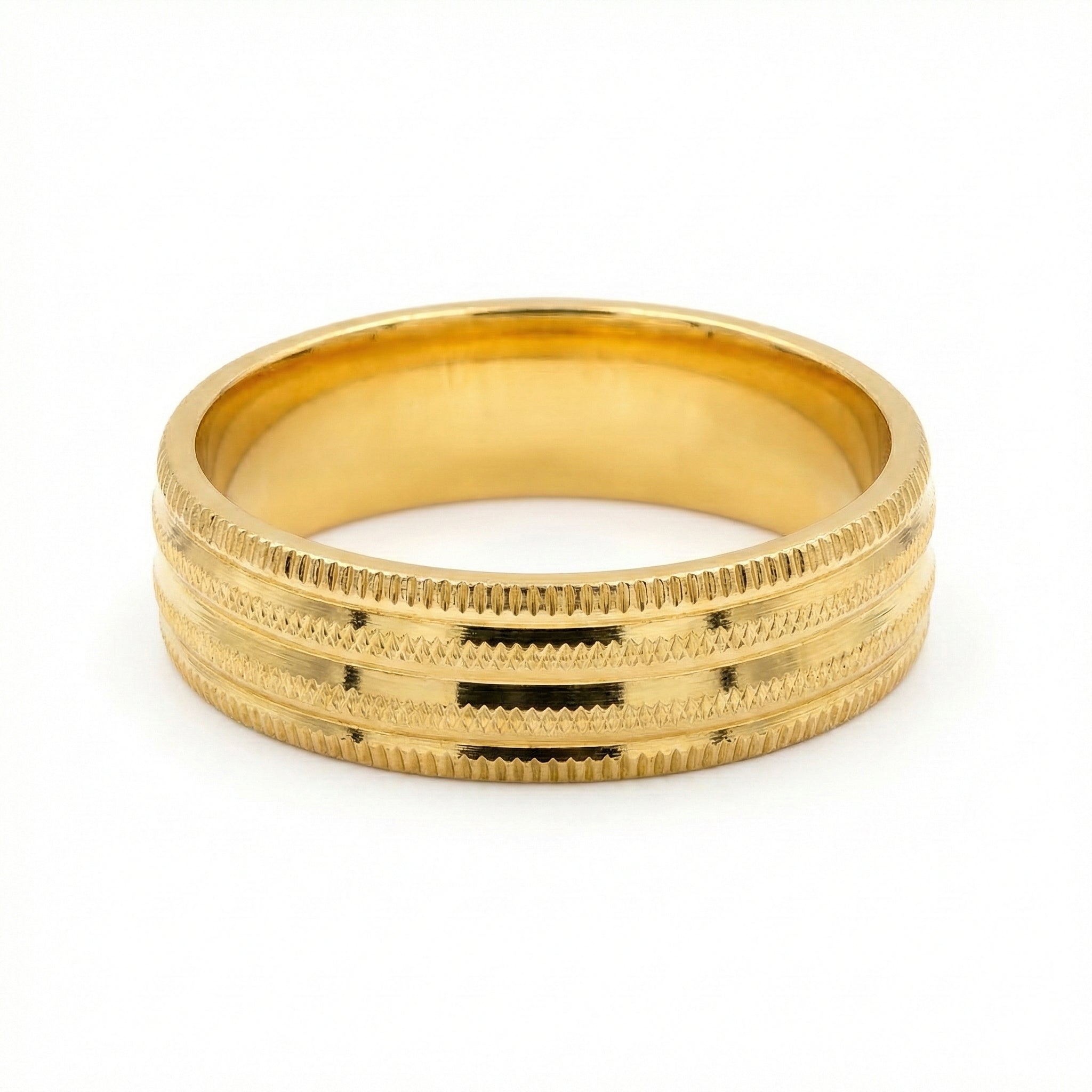 Gold ring with textured design on a white background