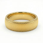 Gold ring with textured band on a white background