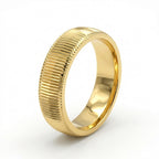 Gold ring with textured design on a white background
