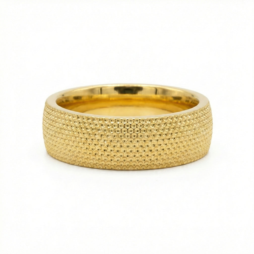 Gold ring with textured surface on a white background