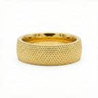 Gold ring with textured surface on a white background