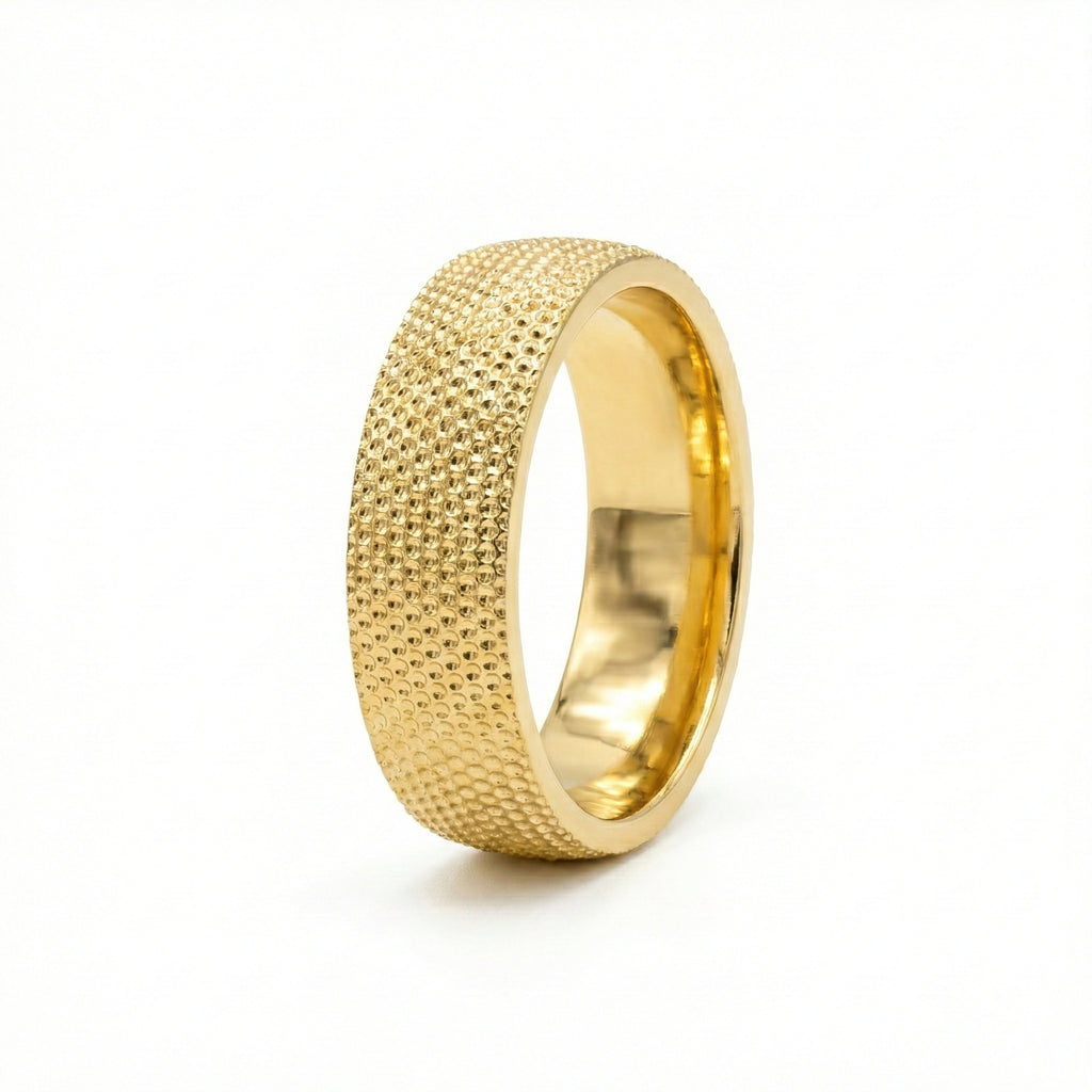 Gold ring with textured surface on a white background