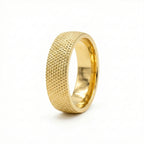 Gold ring with textured surface on a white background