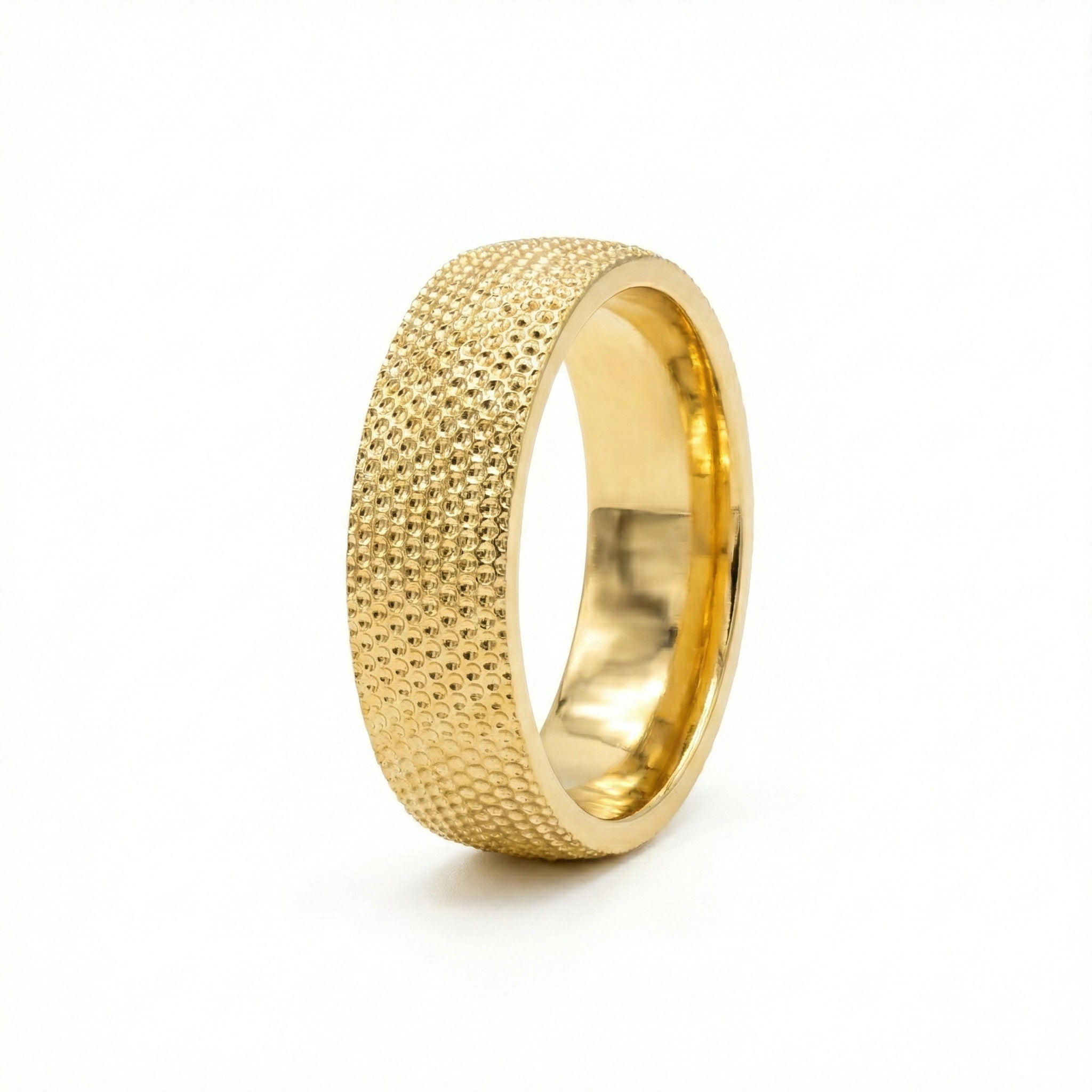 Gold ring with textured surface on a white background