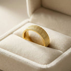 Gold ring with textured design in a jewelry box