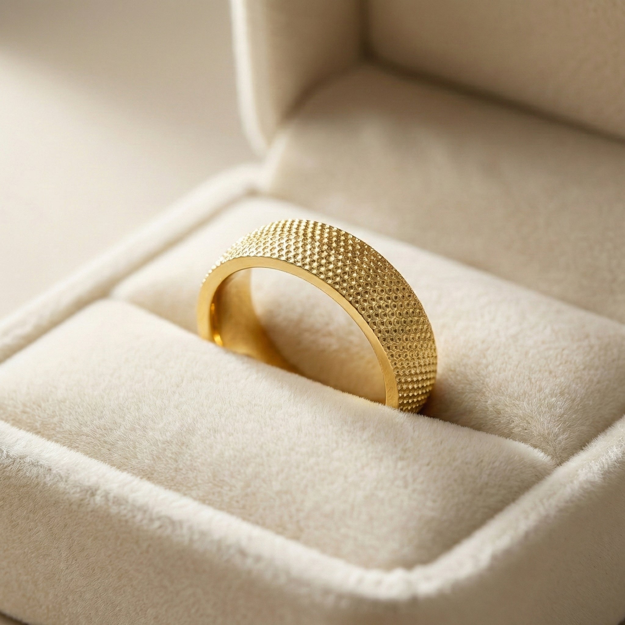 Gold ring with textured design in a jewelry box